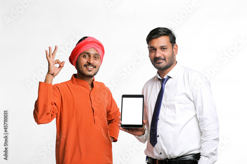 Indian Farmer showing tablet with bank officer or corporate government employee on white background. photo