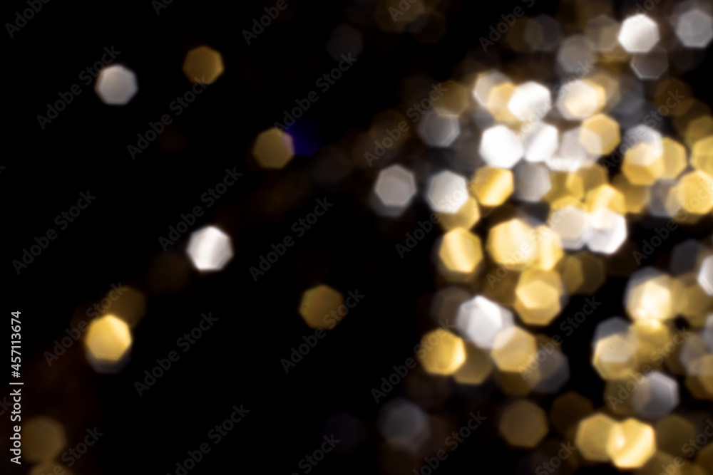 Fototapeta premium Golden and silver blurred bokeh lights on black background. Glitter sparkle stars for celebrate. Overlay for your design