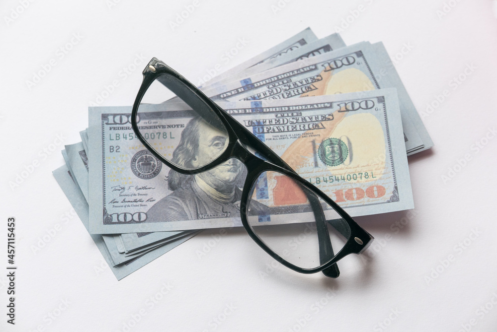A dollar money or bank notes with glasses on a white background. A dollar money or bank notes with glasses on a white background.