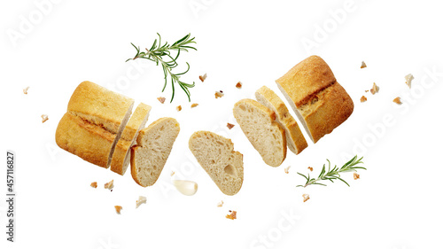 Cutting fersh baked ciabatta loaf with crumbs and rosemary herb twig flying isolated on white