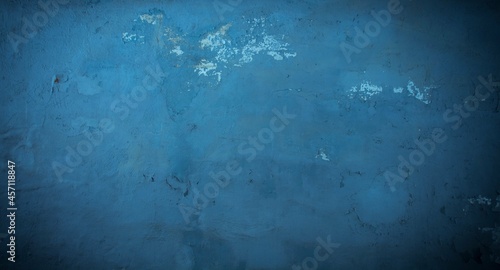 Old blue wall in spots, cracks, stains. Painted concrete wall in abstract grunge style loft. Vintage wall background texture for backgrounds, portraits, posters.