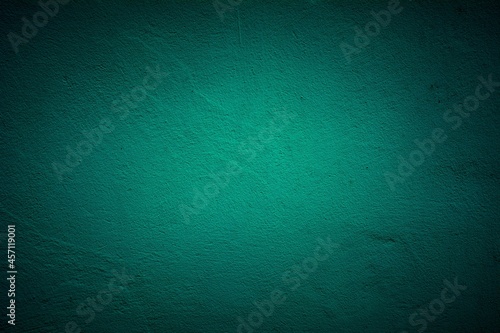 Old green wall in spots, cracks, stains. Painted concrete wall in abstract grunge style loft. Vintage wall background texture for backgrounds, portraits, posters.
