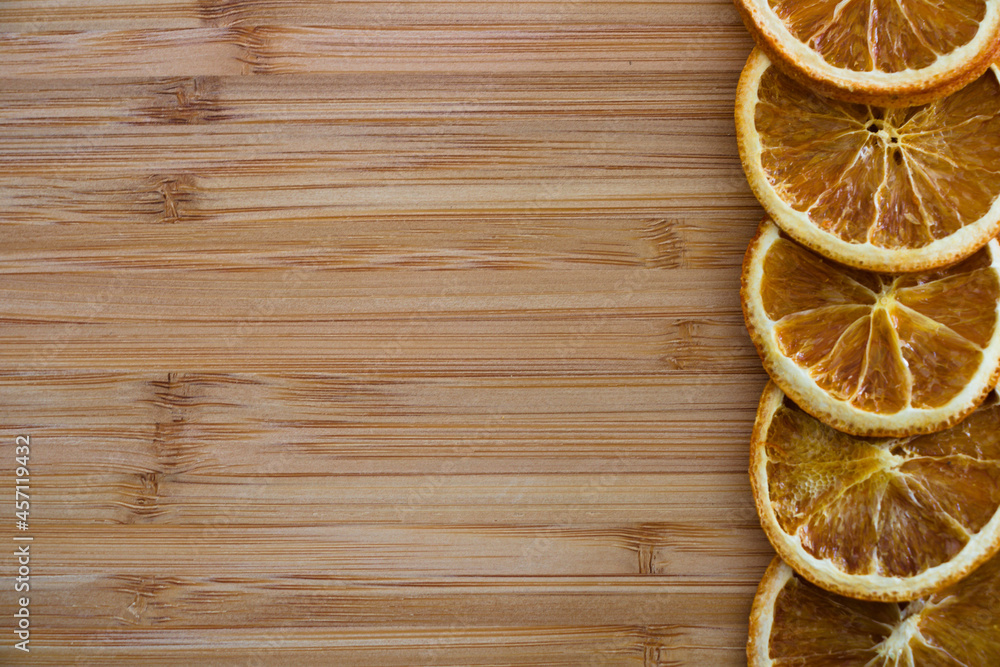 Dried orange slices in a row isolated on wooden background with copy space Dried orange slices in a row isolated on wooden background with copy space