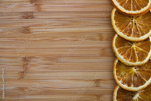 Dried orange slices in a row isolated on wooden background with copy space