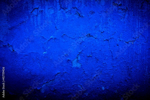 Old blue wall in spots, cracks, stains. Painted concrete wall in abstract grunge style loft. Vintage wall background texture for backgrounds, portraits, posters.