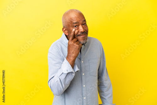 Cuban Senior isolated on yellow background showing something