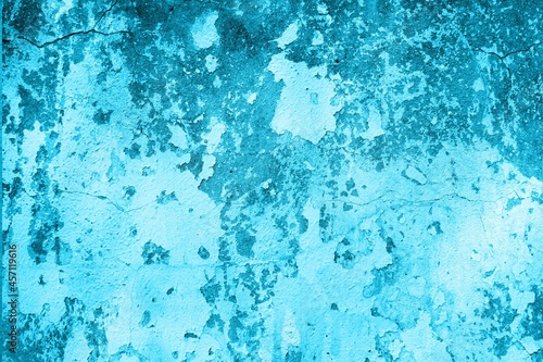 Old blue wall in spots, cracks, stains. Painted concrete wall in abstract grunge style loft. Vintage wall background texture for backgrounds, portraits, posters. © Ponomus