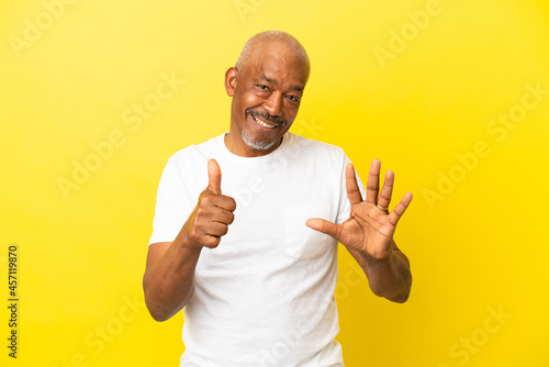 Cuban Senior isolated on yellow background counting six with fingers