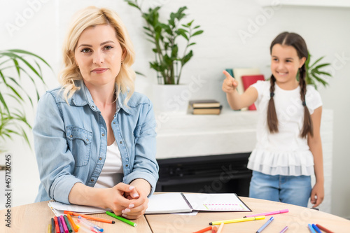 Mom explains something to her daughter, daughter laughs in response
