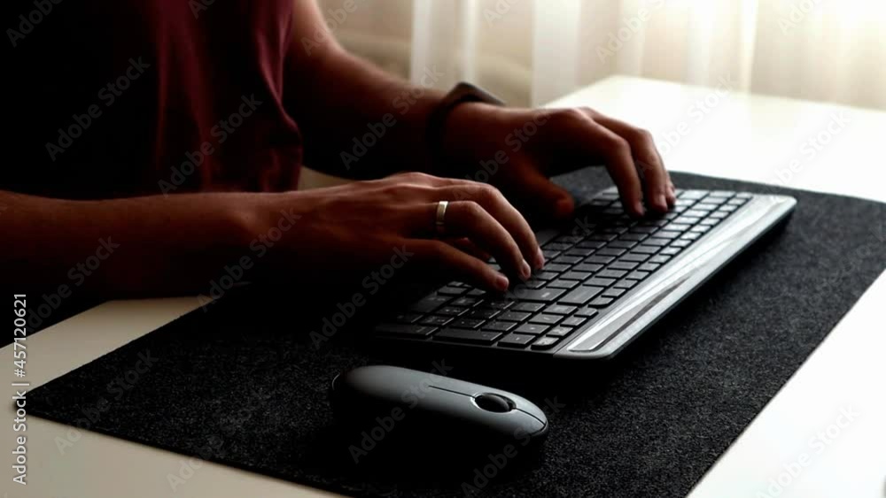 Close up of man typing on the keyboard and using mouse. Work from home alone. Minimalism interior Close up of man typing on the keyboard and using mouse. Work from home alone. Minimalism interior