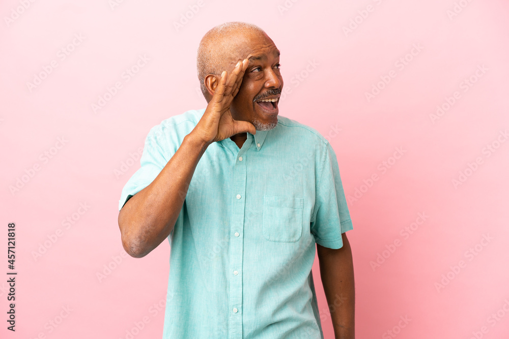 Cuban senior isolated on pink background shouting with mouth wide open to the side Cuban senior isolated on pink background shouting with mouth wide open to the side