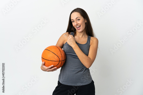 Young woman playing basketball over isolated white background celebrating a victory