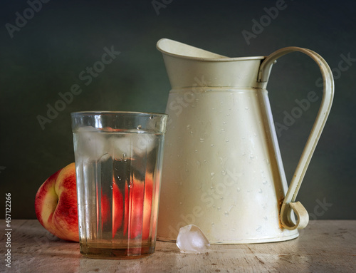 Still life with a glass of ice water, a peach and a jug. Vintage.