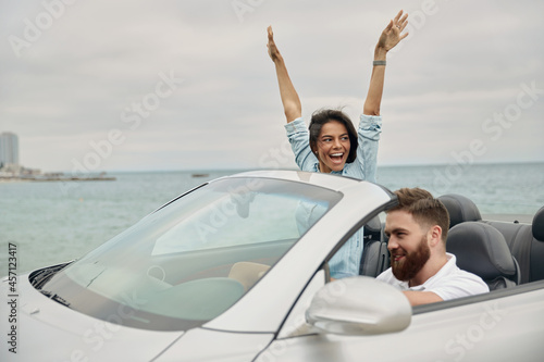 Young european couple riding in cabriolet car