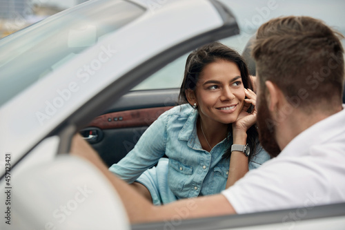 Young european couple riding in cabriolet car