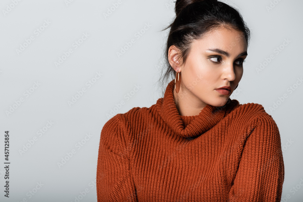 pretty young woman in earrings and knitted sweater looking away isolated on grey pretty young woman in earrings and knitted sweater looking away isolated on grey
