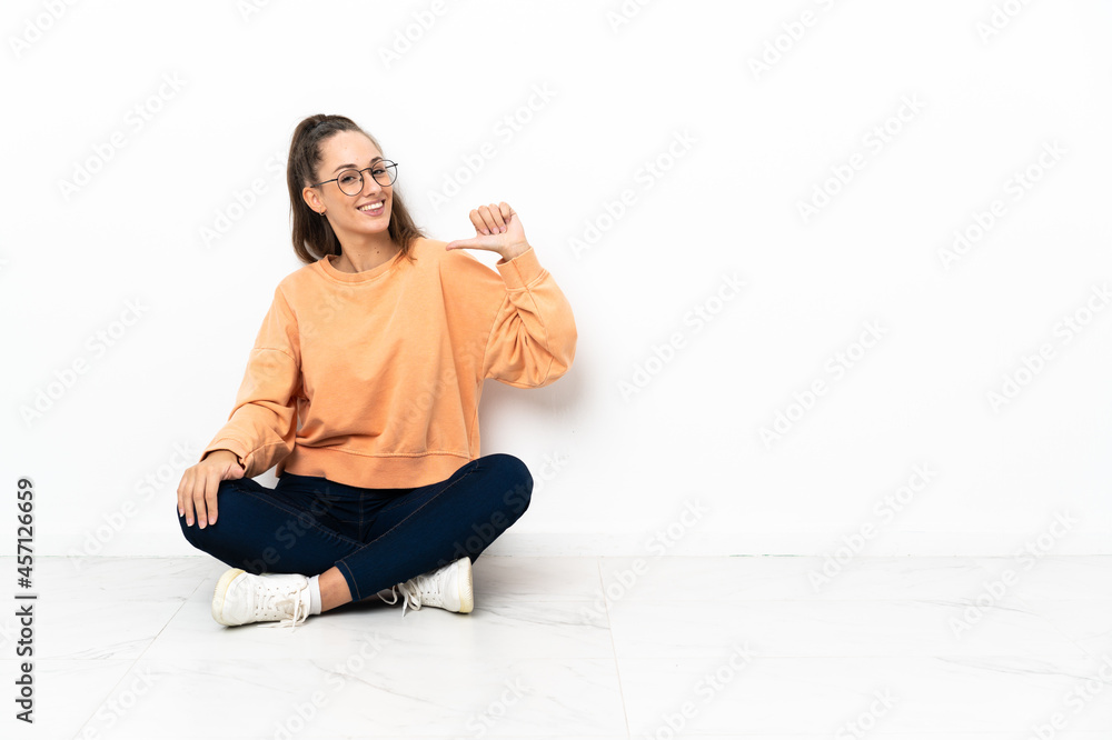 Young woman sitting on the floor proud and self-satisfied Young woman sitting on the floor proud and self-satisfied