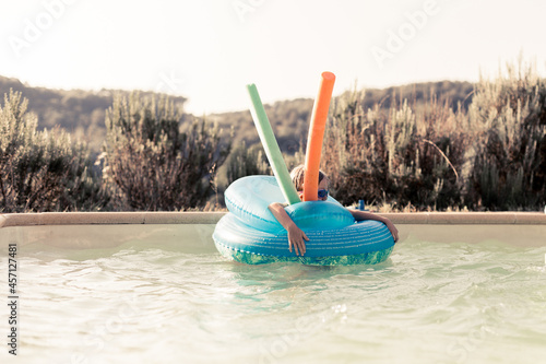 enfant fille dans la piscine avec des bouée photo