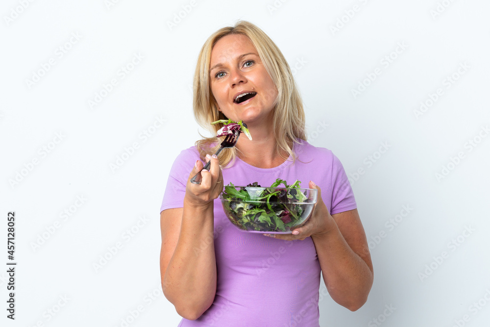 Middle age Lithuanian woman isolated on white background holding a bowl of salad with happy expression Middle age Lithuanian woman isolated on white background holding a bowl of salad with happy expression