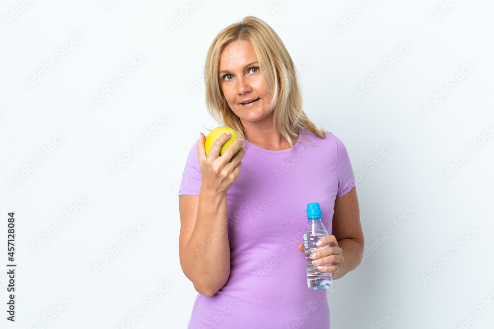 Middle age woman isolated on white background with an apple and with a bottle of water Middle age woman isolated on white background with an apple and with a bottle of water