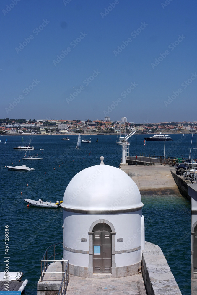 picturesque sailing boats yachts,  white tower on the banks near Lisbon, Portugal harbor,shore of the atlantic azure ocean in Cascais