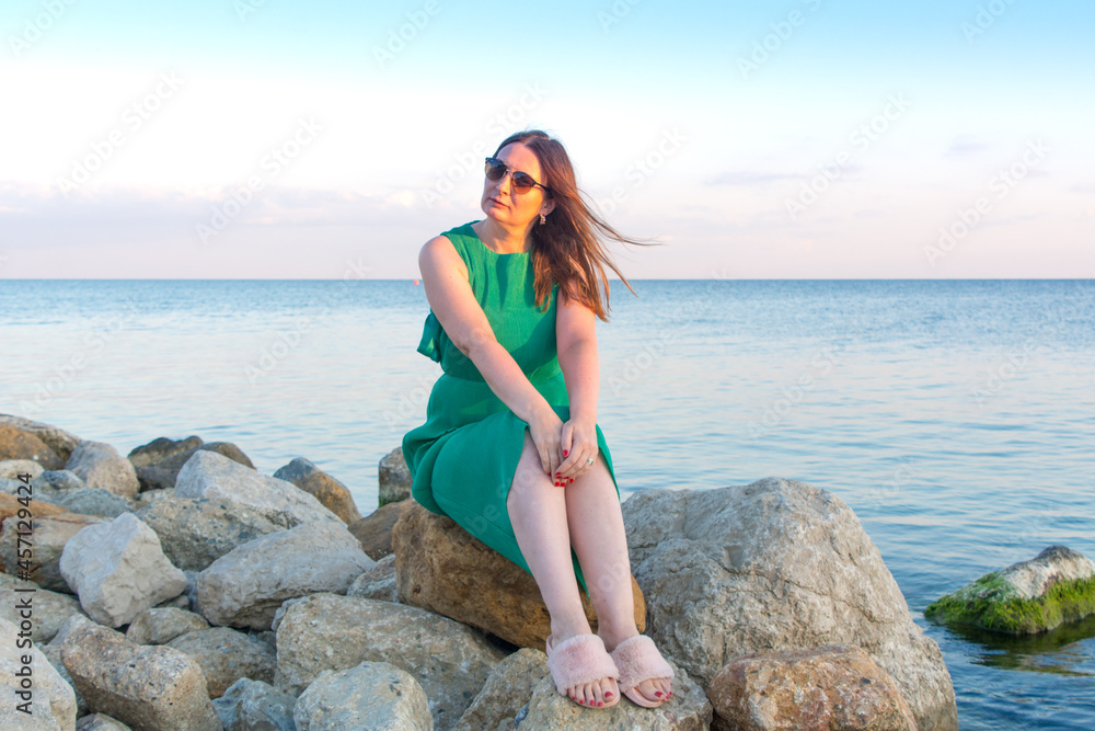 Russia, Crimea, Feodosia, Primorsky village, August 20, 2020. Attractive woman in sunglasses against the background of the Black Sea.