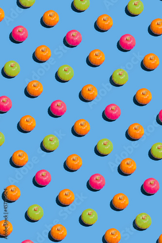 Fototapeta Naklejka Na Ścianę i Meble -  Creative 2021 Halloween pattern concept with orange, pink and green pumpkin against blue background. Minimal colorful decoration and craft concept, visual geometric arrangement.