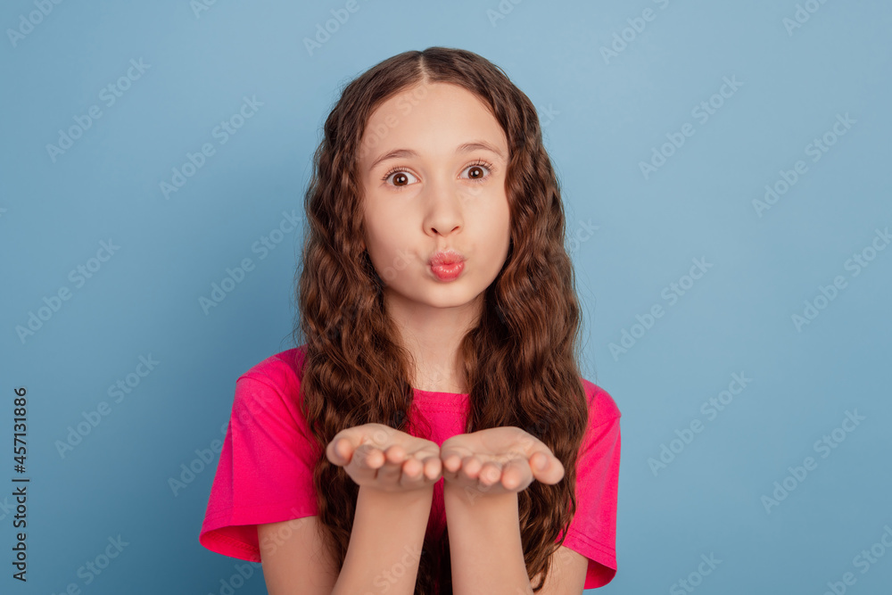 Portrait of affectionate dreamy pretty girl hold hands blow air kiss on blue background Portrait of affectionate dreamy pretty girl hold hands blow air kiss on blue background