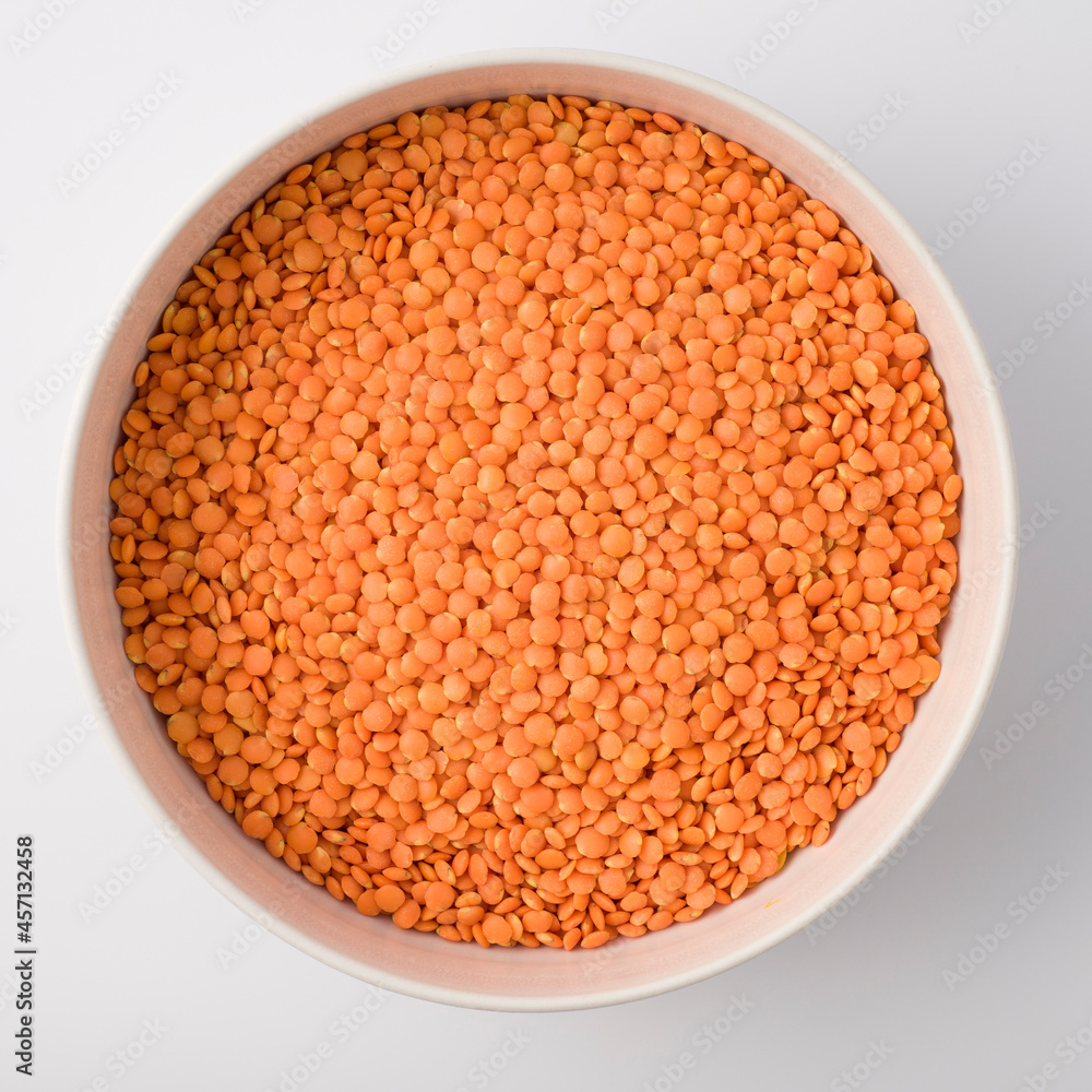 Red or Pink Lentils on round large white plate. isolated on white. Top view Red or Pink Lentils on round large white plate. isolated on white. Top view