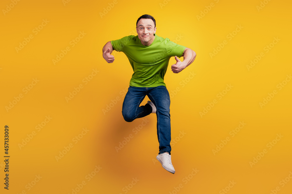 Portrait of crazy energetic guy jump sport concept on yellow wall
