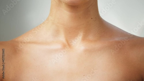 Young woman clavicles close-up, model with smooth healthy skin. Female shoulders, naked body. Beauty and body care concept. Unrecognizable person with bare neck and chest on white background. photo