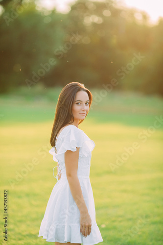 Fototapeta Naklejka Na Ścianę i Meble -  Young joyful woman walks in meadow on sunny day.