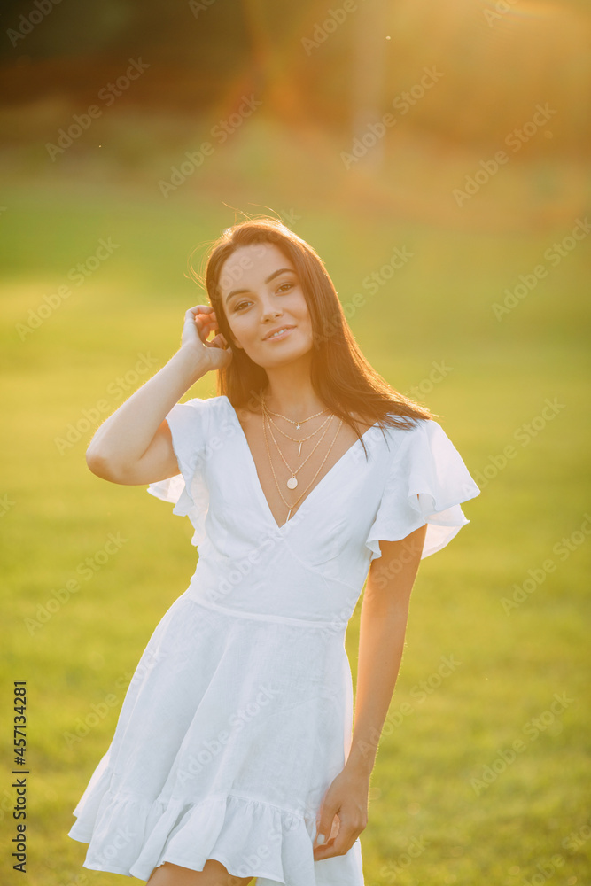 Young joyful woman walks in meadow at sunset. Young joyful woman walks in meadow at sunset.