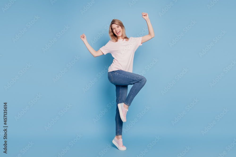 Portrait of ecstatic crazy lady champion triumph concept raise hands on blue background