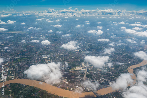 Aerial view scene of Bangkok urban city which are under white fluffy clouds and clear bright blue sky background