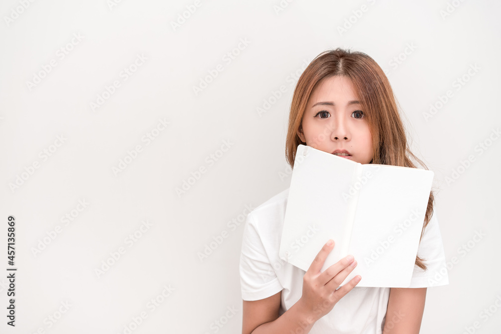 Young attractive asian student holding books in her arm on white background. School girl with a books to read for homework. Young attractive asian student holding books in her arm on white background. School girl with a books to read for homework.
