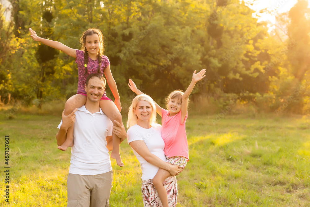Fototapeta premium Happy family walking in field and looking at sunset