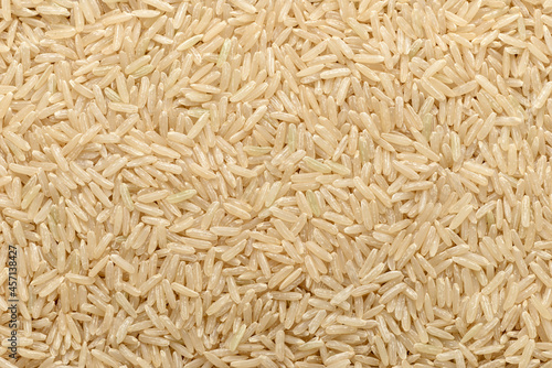 food background of uncooked long brown rice, top view