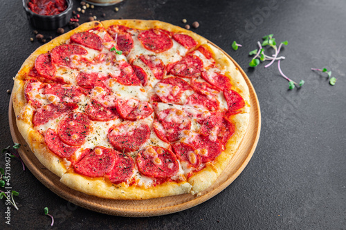 Pizza salami or pepperoni sausage, cheese, tomato sauce, dough fresh portion ready to eat meal snack on the table copy space food background rustic. top view