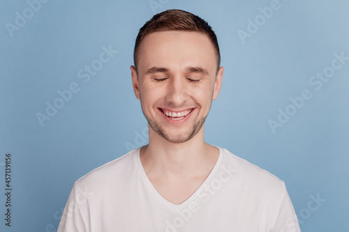 Photo of young handsome man happy positive smile close eyes dream cheerful toothy isolated over blue color backgrund