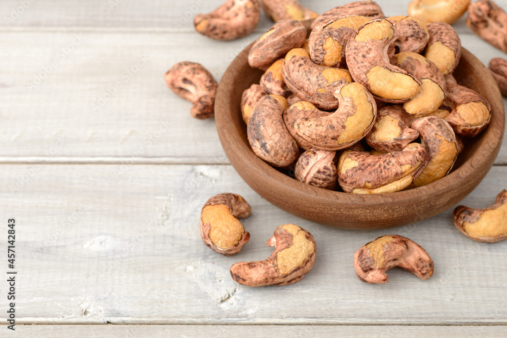 roasted cashew nuts in the wooden bowl on the table roasted cashew nuts in the wooden bowl on the table