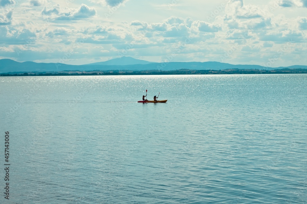 Two girls are canoeing on the Trasimeno lake (Umbria, Italy, Europe)