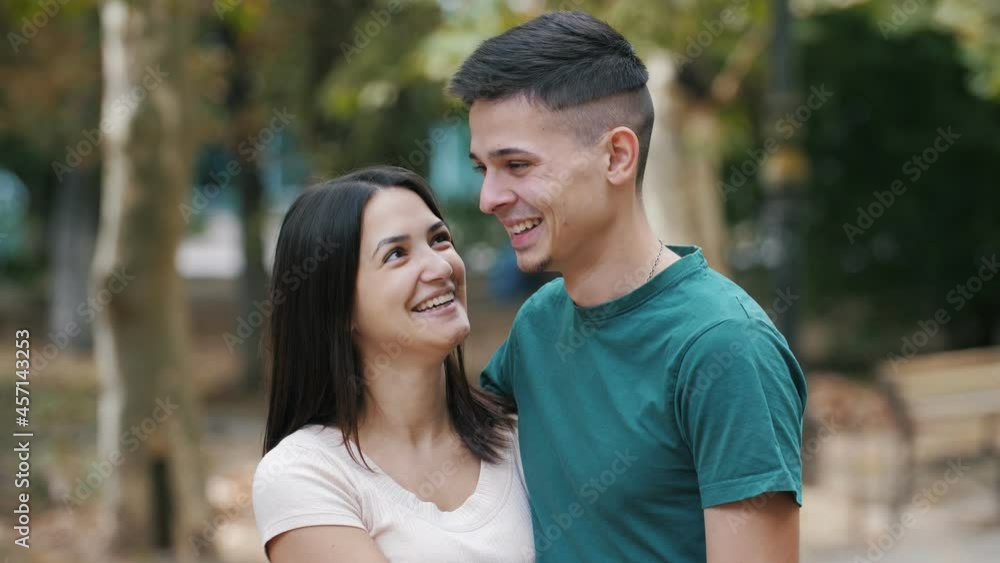 Happy young couple standing , hugging and kissing each other in street in summer Happy young couple standing , hugging and kissing each other in street in summer