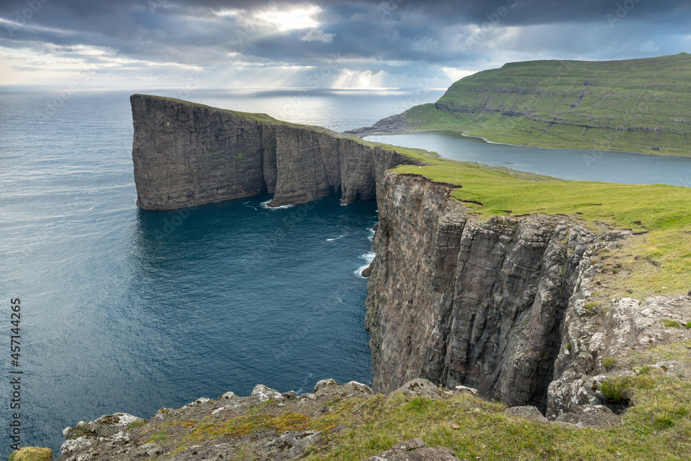 The top of the mountain of Faroe islands. A view of high peaks of mountains on a sunny day. Ocean view. 
Beautiful panoramic view. Northern Europe. Travel concept
