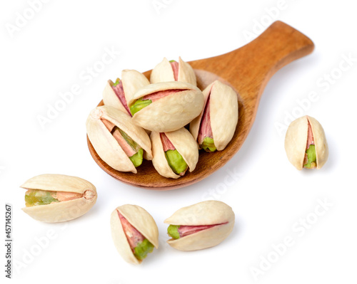 pistachios nuts in the wooden spoon, isolated on white