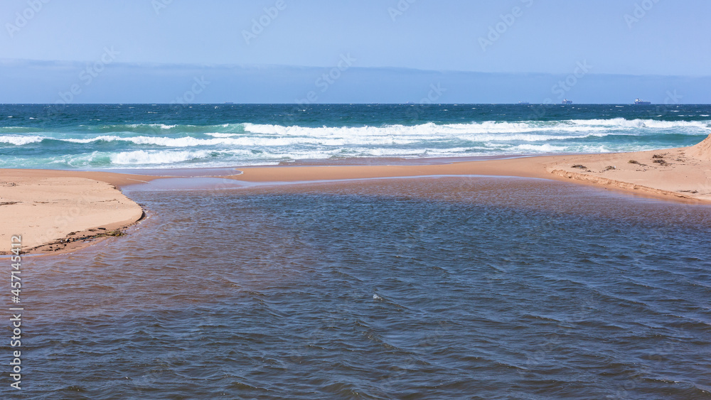 Beach sandbanks with open river water flowing from lagoon towards the ...