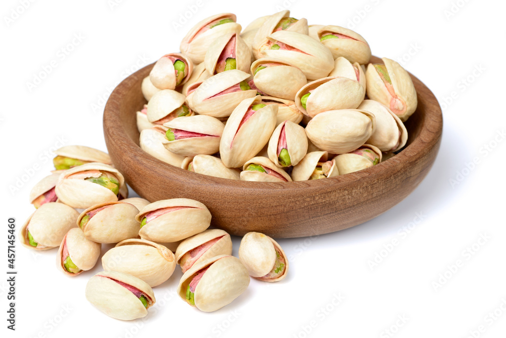 pistachios nuts in the wooden plate, isolated on white pistachios nuts in the wooden plate, isolated on white