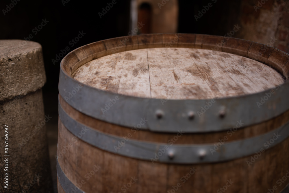 Old wooden barrel in a wine cellar Background with short depth of field.