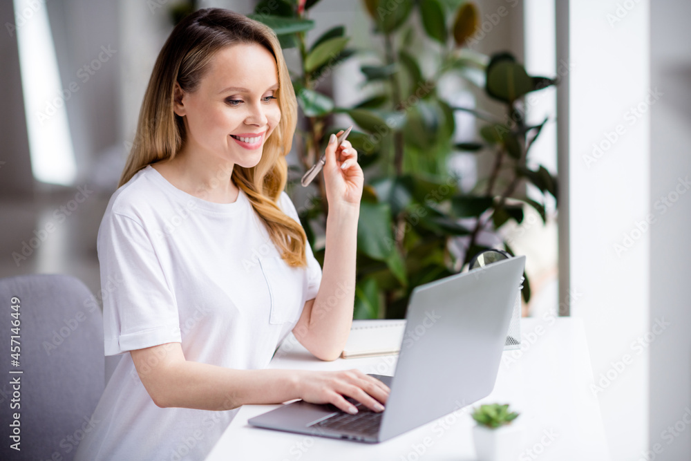 Profile side portrait of attractive cheerful girl staying home using laptop studying at light white home house indoors