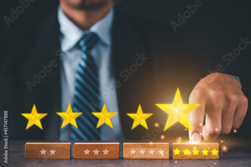 Businessman choose five-star wooden blocks. Satisfaction survey concept. Referral and customer service.